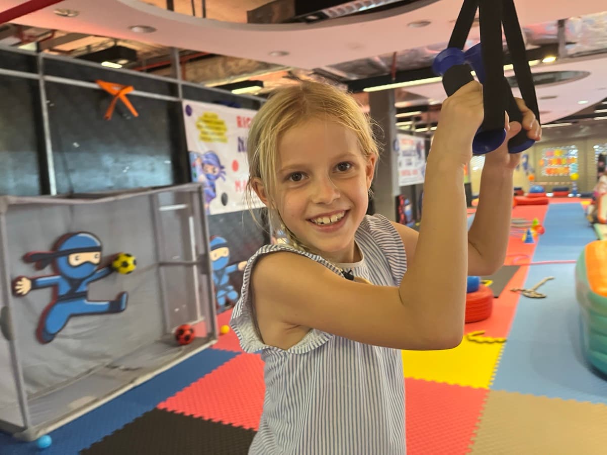 A young ninja smiling on the rings